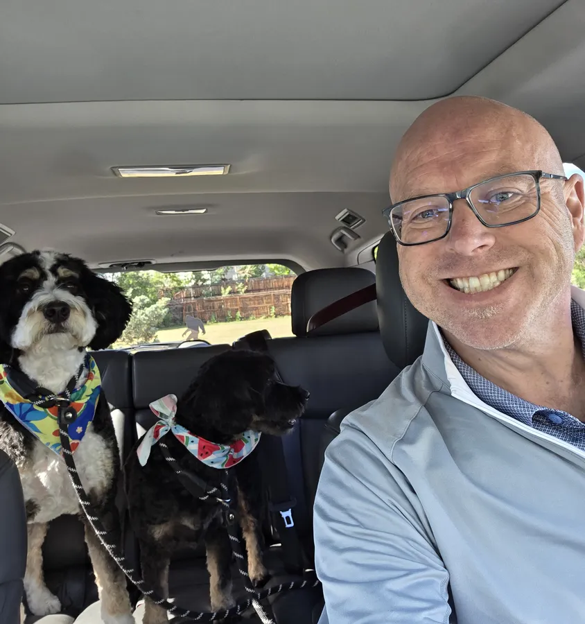 Mark smiling in the car with Bernie and Teddi in the back seat